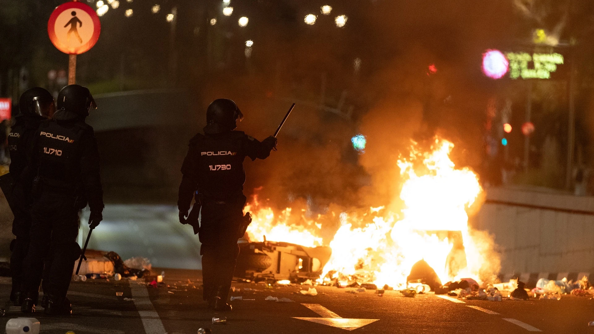 Dos policías frente a una barricada de los manifestantes concentrados en la sede del PSOE en la calle Ferraz de Madrid