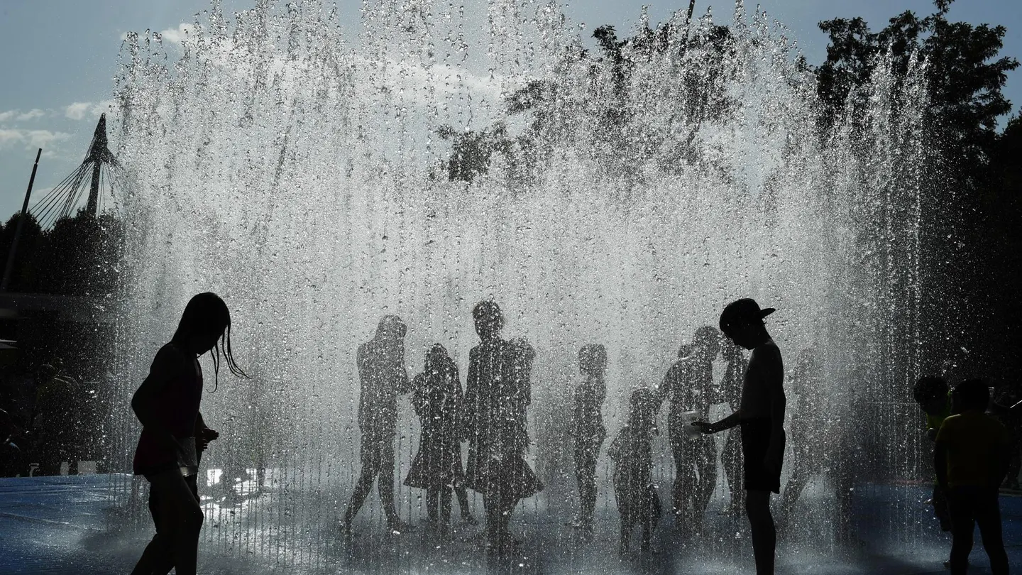 Personas mojándose y aclimatándose en una fuente muertes por calor en Europa