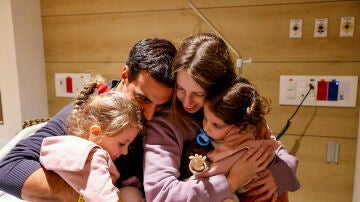 Aviv Asher (d), de dos años, su hermana Raz Asher (i) de 4 años y su madre Doron (2d) se reúnen con el padre (2i) de la familia 