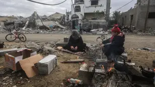 Palestinos sentados en torno a la destrucción en el pueblo de Khuza'a, cerca de la valla fronteriza entre Israel y el sur de la Franja de Gaza.