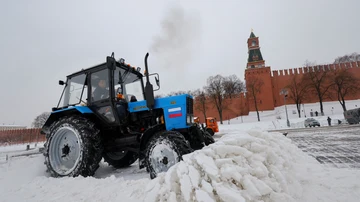 Un trabajador opera un tractor para retirar la nieve de una plaza de Moscú tras la nevada.