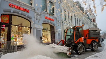 A worker operates a machine while clearing snow on a street after heavy snowfall in Moscow, Russia, Nov. 27, 2023.