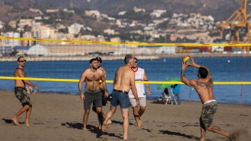 Jóvenes disfrutan en la playa de la Misericordia de Málaga, de los 29,9 grados centígrados que se han alcanzado hoy en la capital de la Costa del Sol,