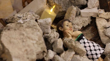 Representación del niño Jesús entre escombros en una iglesia de Belén, Cisjordania, en plena guerra en Gaza