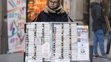 Una mujer vendiendo Lotería de Navidad de 2023 de Doña Manolita en el centro de Madrid
