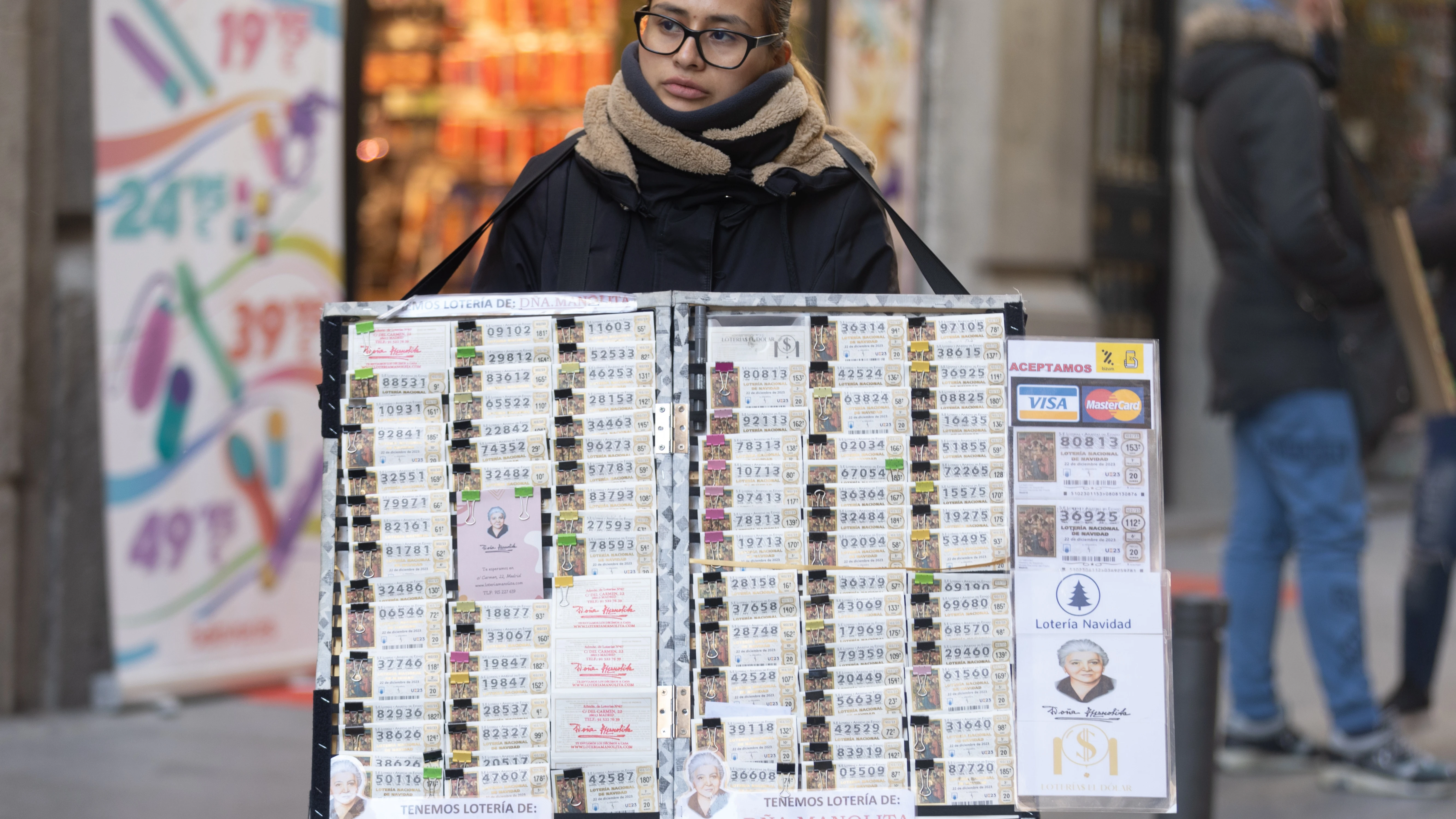 Una mujer vendiendo Lotería de Navidad de 2023 de Doña Manolita en el centro de Madrid