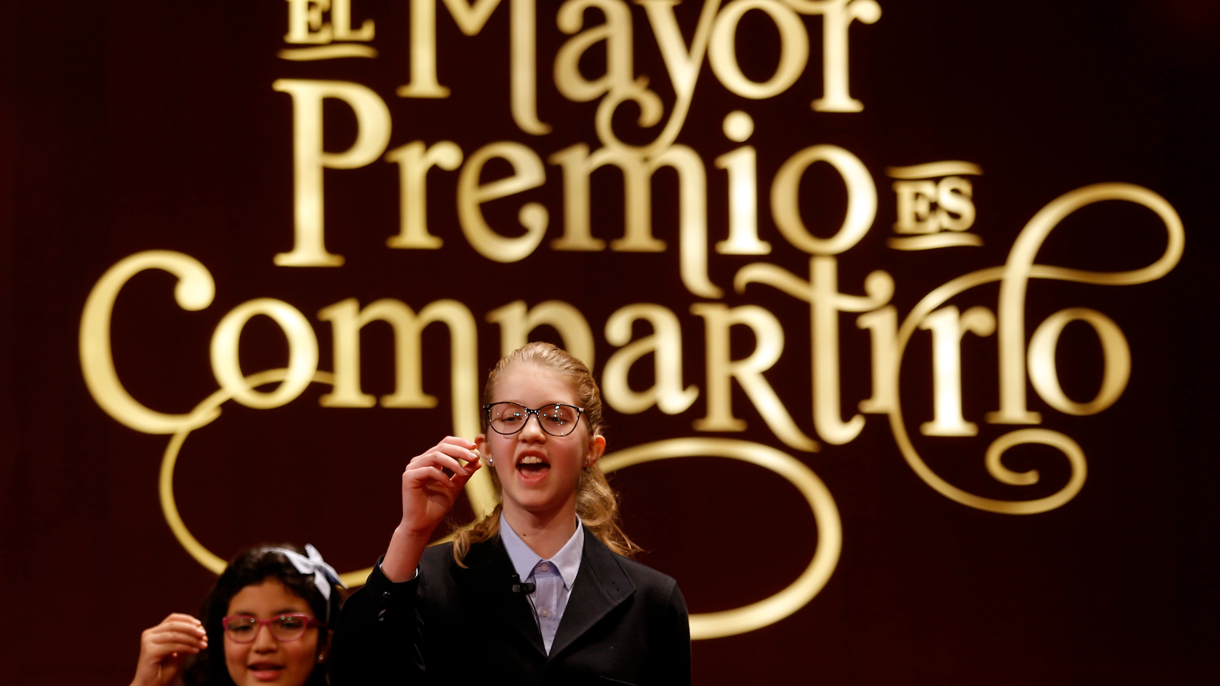 Dos niñas de San Ildefonso cantando los premios de la Lotería de Navidad en 2016