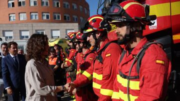 Isabel Díaz Ayuso saluda a varios bomberos en una visita al Parque de Bomberos de Las Rozas. 