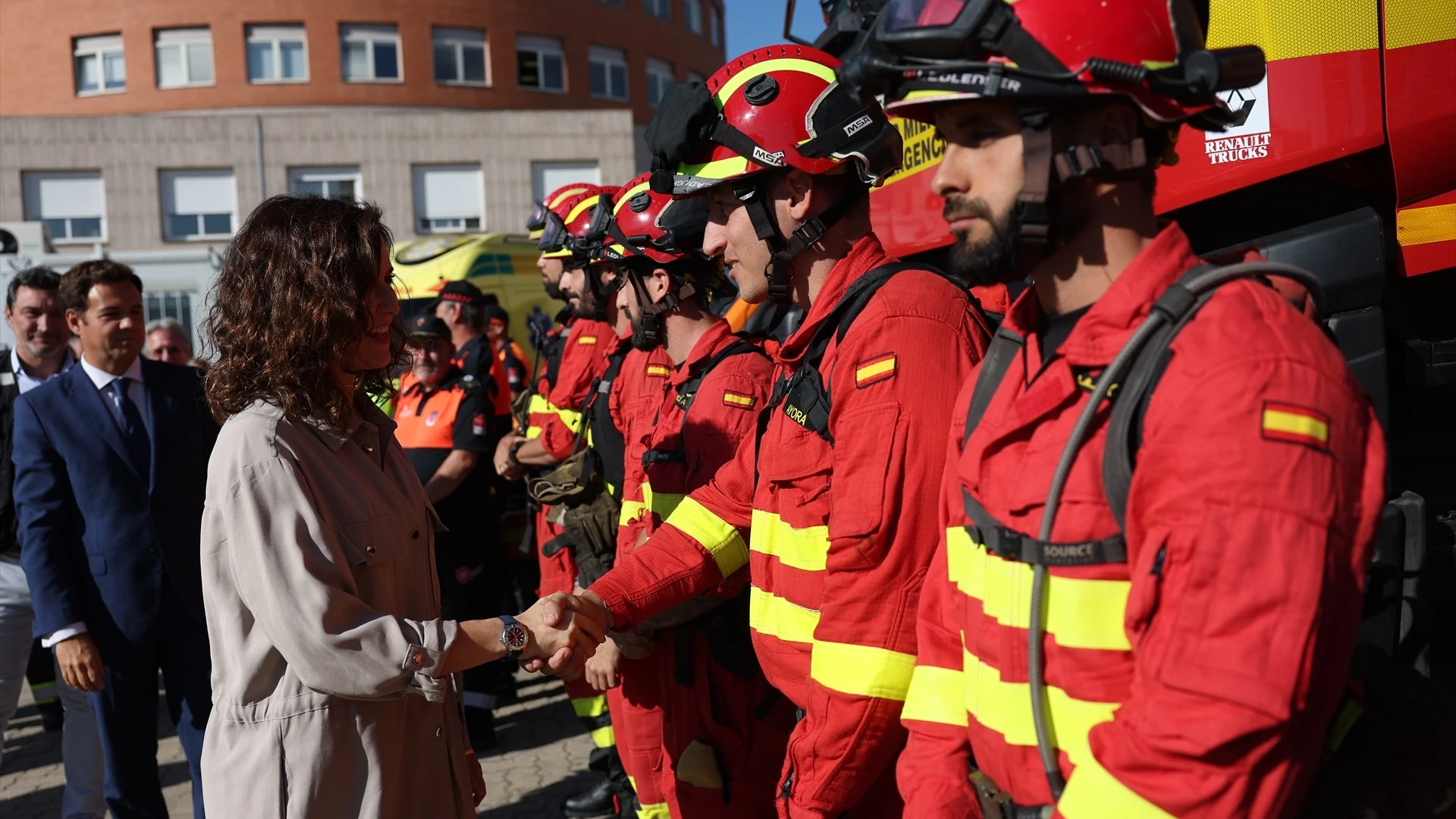 Isabel Díaz Ayuso saluda a varios bomberos en una visita al Parque de Bomberos de Las Rozas. 