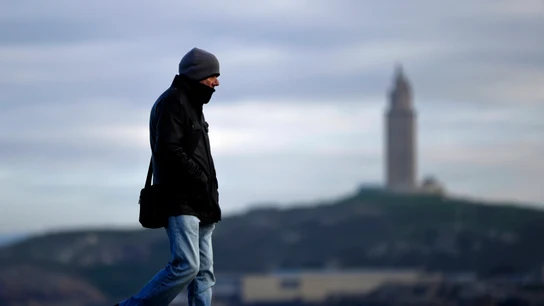 Imagen de una persona paseando abrigada para protegerse del frío Imagen de una persona paseando abrigada para protegerse del frío