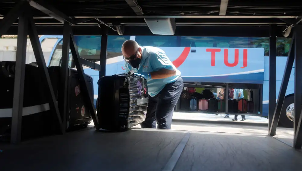 Conductor metiendo las maletas en el maletero del autobús 