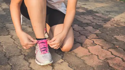 Persona atándose las zapatillas Persona atándose las zapatillas