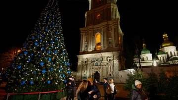 La gente se reúne junto a un árbol de Navidad para celebrar la víspera de Año Nuevo en Kyiv, Ucrania.