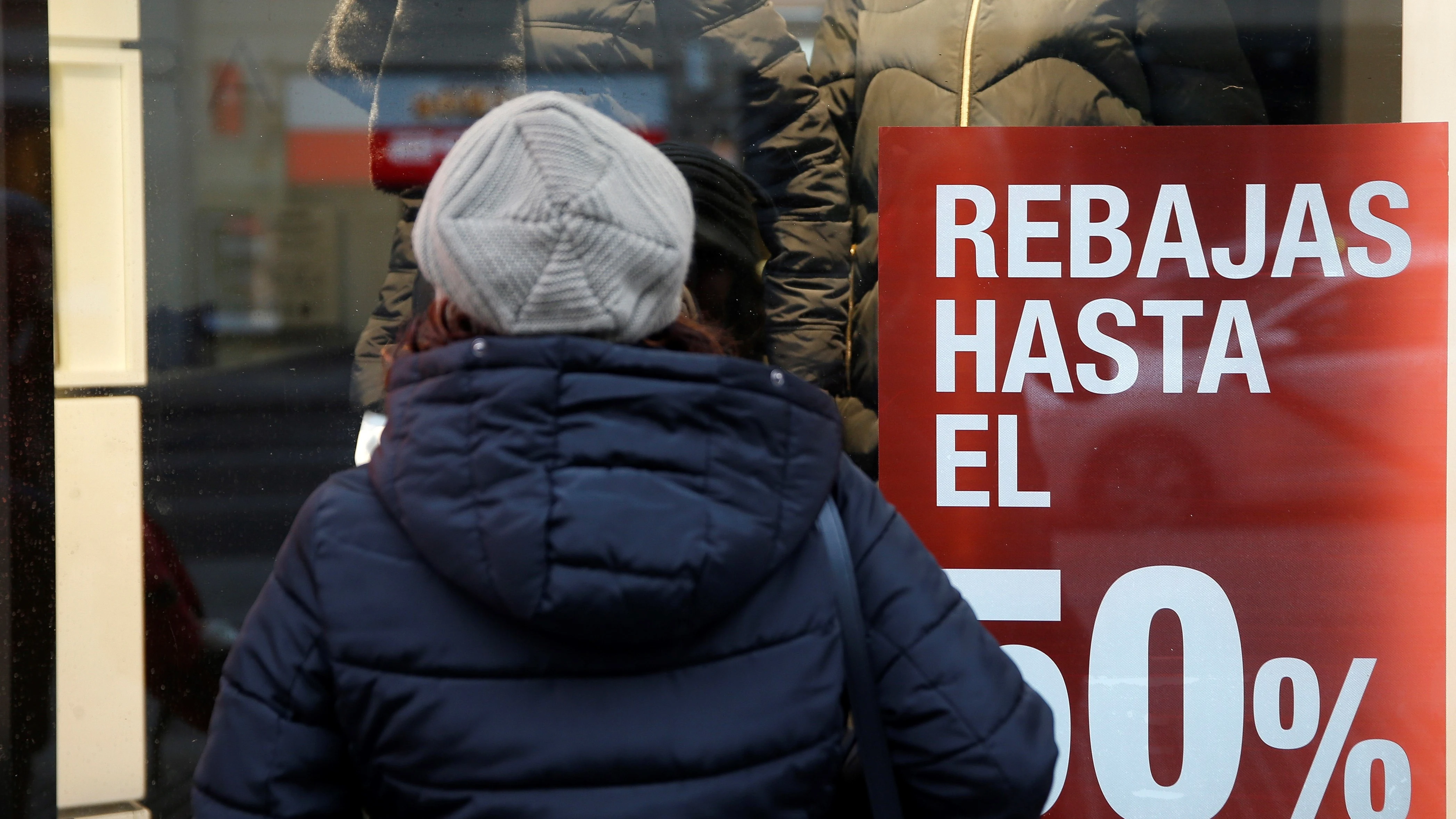 Una persona observa el escaparate de una tienda con rebajas