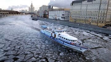 Un barco navega por el río Moskva cubierto de hielo cerca del Kremlin en Moscú, Rusia.