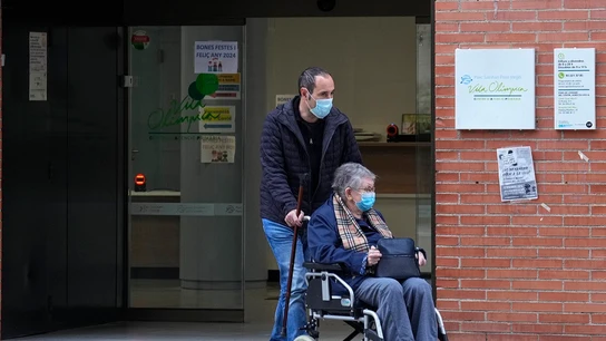 Dos personas salen de un centro de salud con la mascarilla puesta Dos personas salen de un centro de salud con la mascarilla puesta