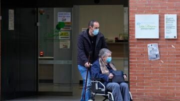 Dos personas salen de un centro de salud con la mascarilla puesta