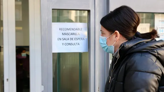 Una persona entra con mascarilla a un centro de salud Una persona entra con mascarilla a un centro de salud