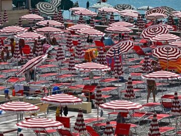 Bañistas buscan refugio del sol en una playa italiana en julio de 2023