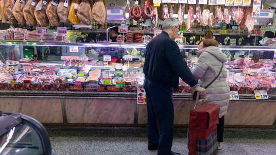 Una pareja compra en una charcutería en un mercado en Madrid (España). Una pareja compra en una charcutería en un mercado en Madrid (España).