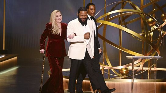 Christine Applegate hace su entrada al escenario de los premios Emmy junto al presentador Anthony Anderson.