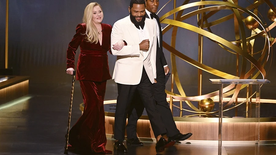 Christine Applegate hace su entrada al escenario de los premios Emmy junto al presentador Anthony Anderson.