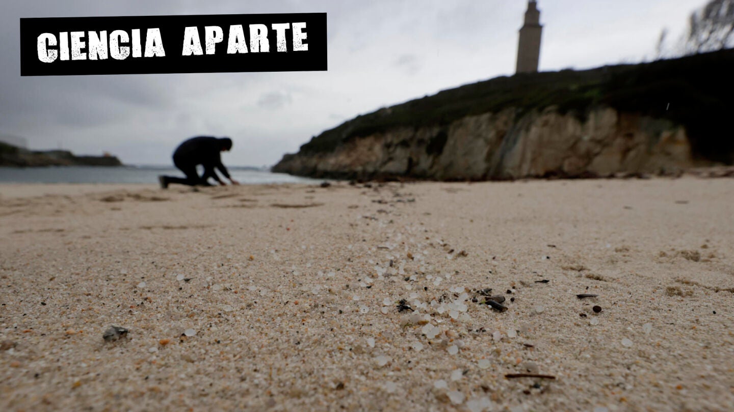 Una persona recoge pellets en la playa de As Lapas, en A Coru&ntilde;a.