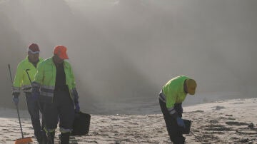 Operarios participan en la recogida de pellets en la playa de Viveiro (Lugo)