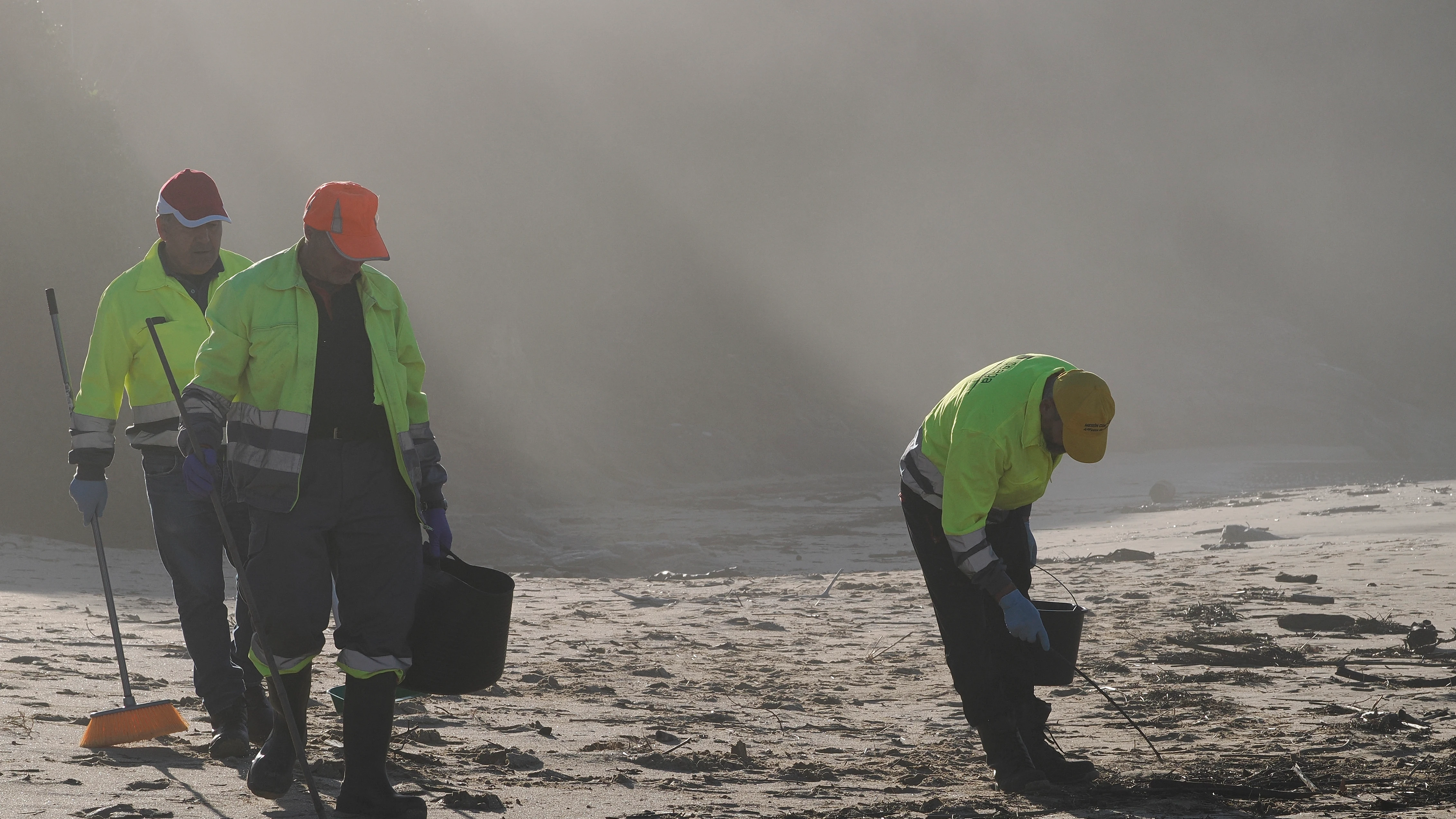 Operarios participan en la recogida de pellets en la playa de Viveiro (Lugo)