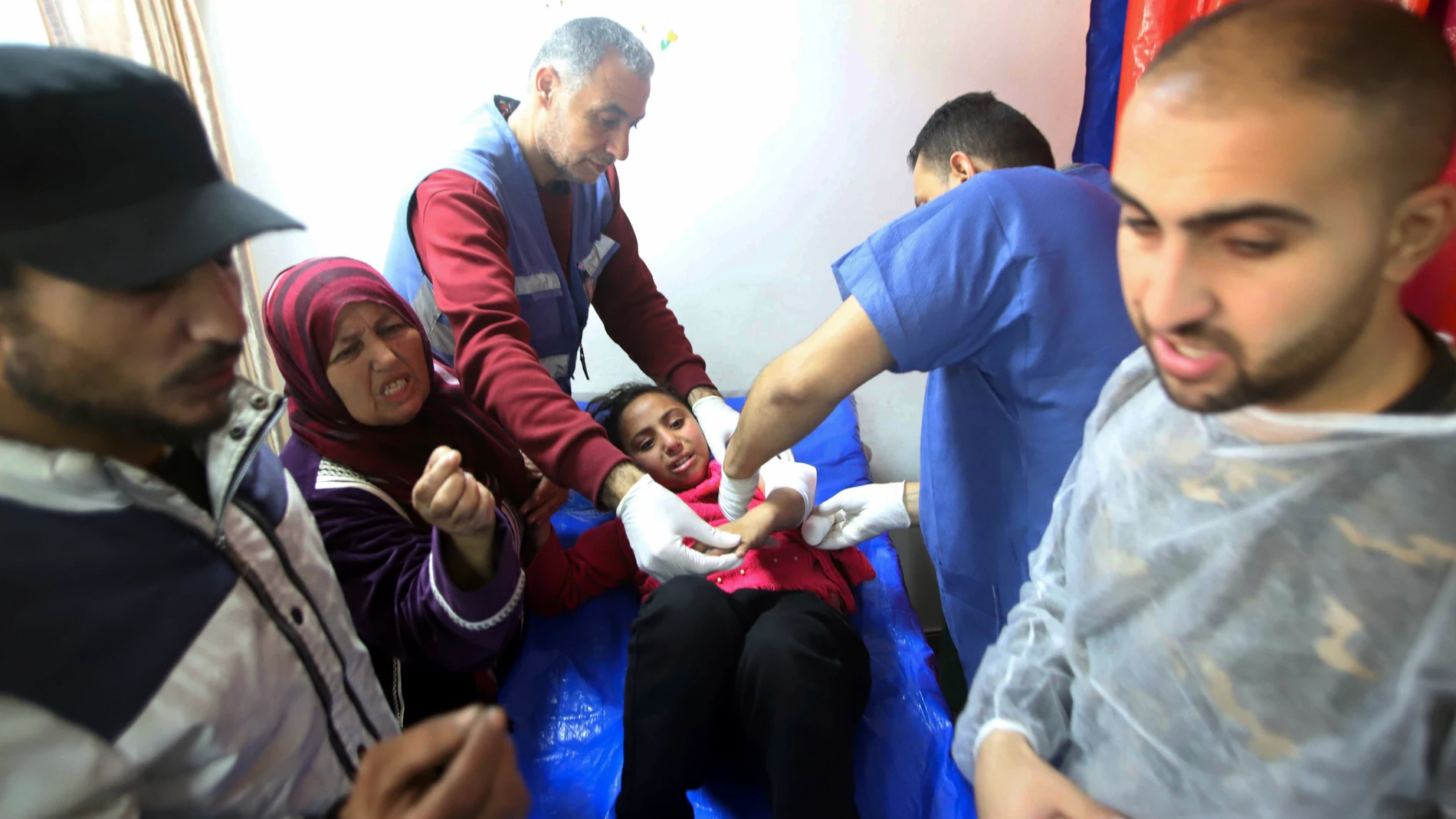 Médicos palestinos atienden a una niña herida en el bombardeo israelí en un edificio de un centro de formación profesional de la UNRWA que los desplazados utilizan como refugio en Jan Younis