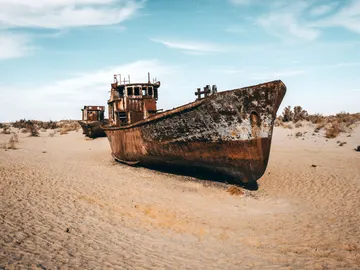 Barcos oxidados abandonados en el cementerio de barcos en la antigua costa del mar de Aral en Moynaq, Uzbekistán Barcos oxidados abandonados en el cementerio de barcos en la antigua costa del mar de Aral en Moynaq, Uzbekistán