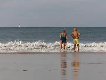 Una pareja conversa en la orilla de la playa de La Concha de San Sebastián, el 28 de enero de 2024. 