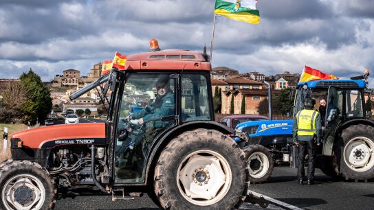 Un agricultor subido a un tractor