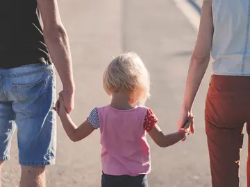 Imagen de archivo de una familia paseando cogida de la mano.