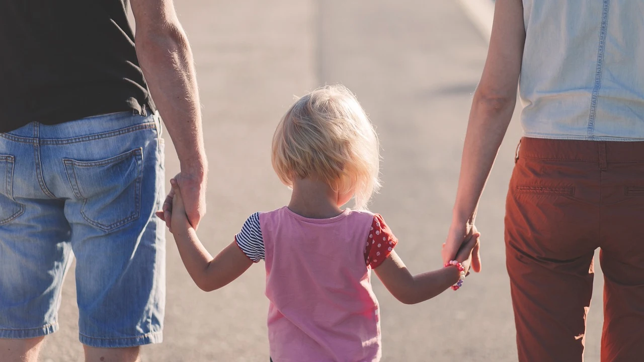 Imagen de archivo de una familia paseando cogida de la mano.