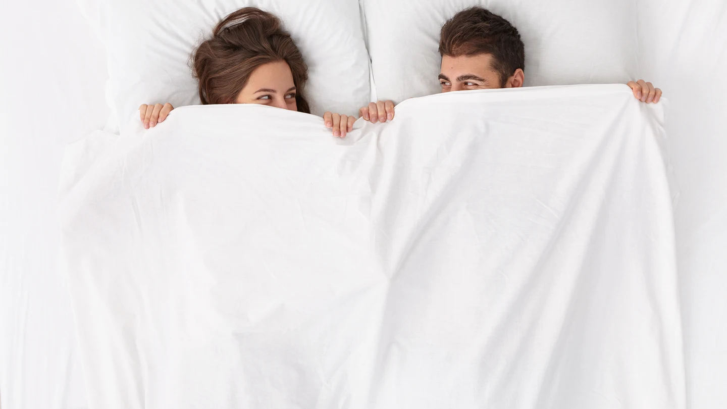 Una pareja durmiendo en una cama. Una pareja durmiendo en una cama.