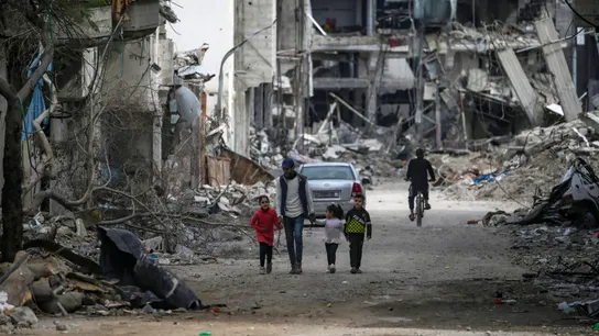 Una familia palestina camina entre la destrucción en el campo de refugiados de Al Bureije (Gaza) Una familia palestina camina entre la destrucción en el campo de refugiados de Al Bureije (Gaza)