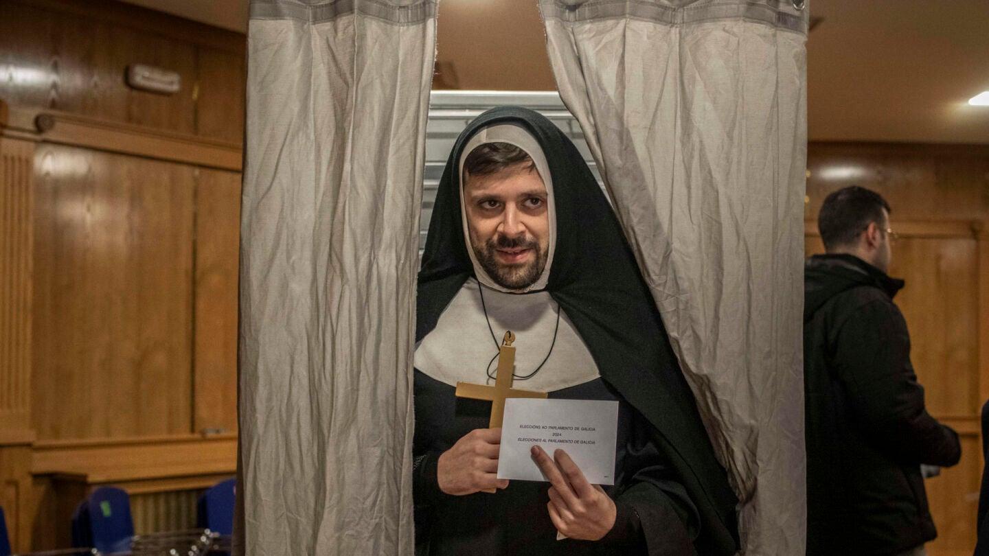 En la imagen, una persona disfrazada vota en un colegio electoral en Xinzo de Limia (Ourense), este domingo. 