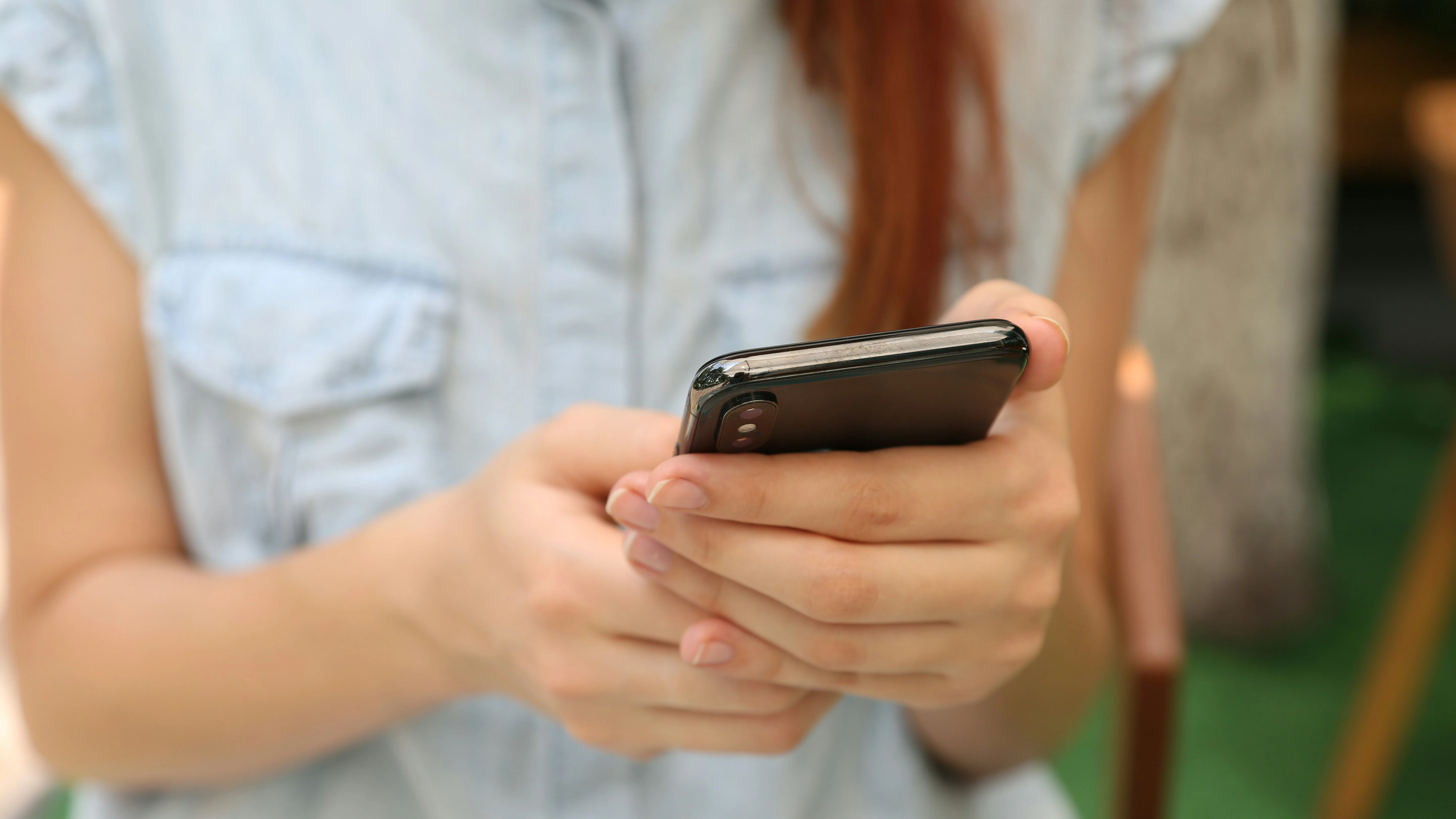 Una mujer consultando un teléfono móvil. 