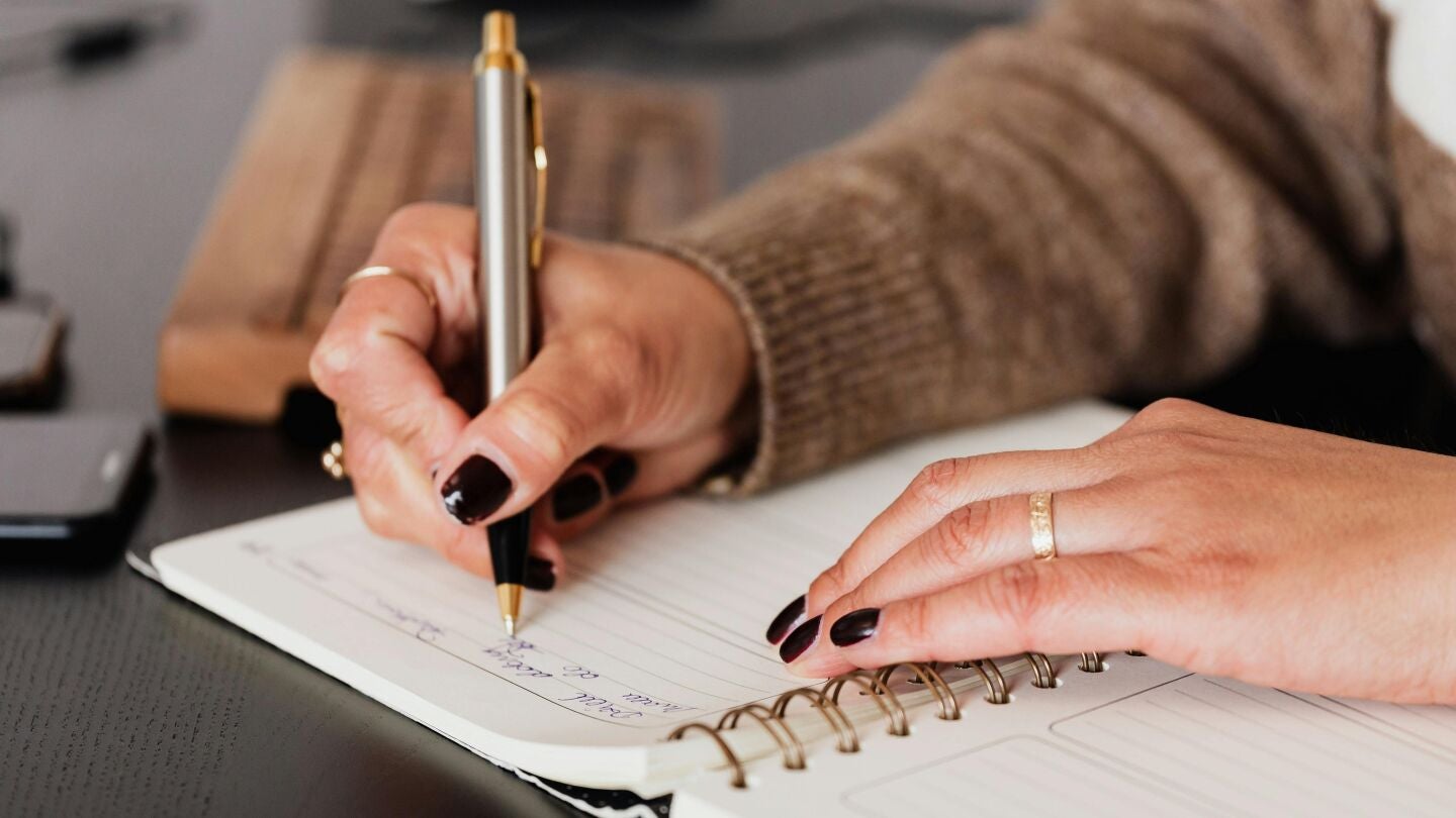 Persona escribiendo en un diario