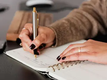 Persona escribiendo en un diario Persona escribiendo en un diario