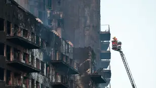 Los bomberos continúan trabajando este viernes tras el fulminante y devastador incendio en un edificio de viviendas de catorce plantas en València, que se ha propagado a otro anexo.