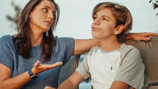 Una madre manteniendo una conversación complicada con su hijo adolescente Una madre manteniendo una conversación complicada con su hijo adolescente