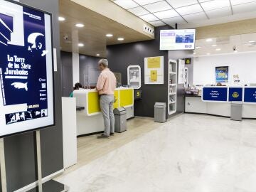 Un hombre es atendido en la oficina de Correos de la calle Conde de Pe&ntilde;alver, a 21 de julio de 2023, en Madrid (Espa&ntilde;a).