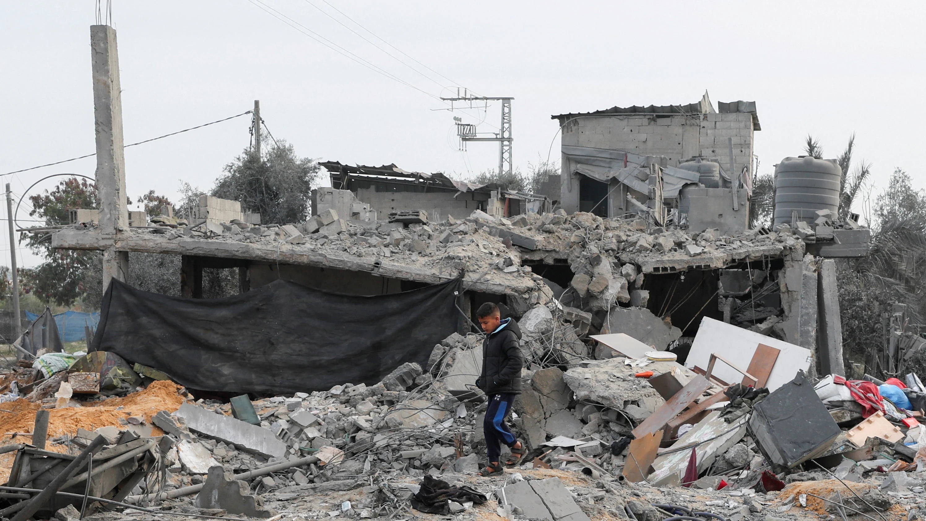 Un niño palestino camina entre los restos de una vivienda devastada por un ataque israelí en Rafah, Gaza