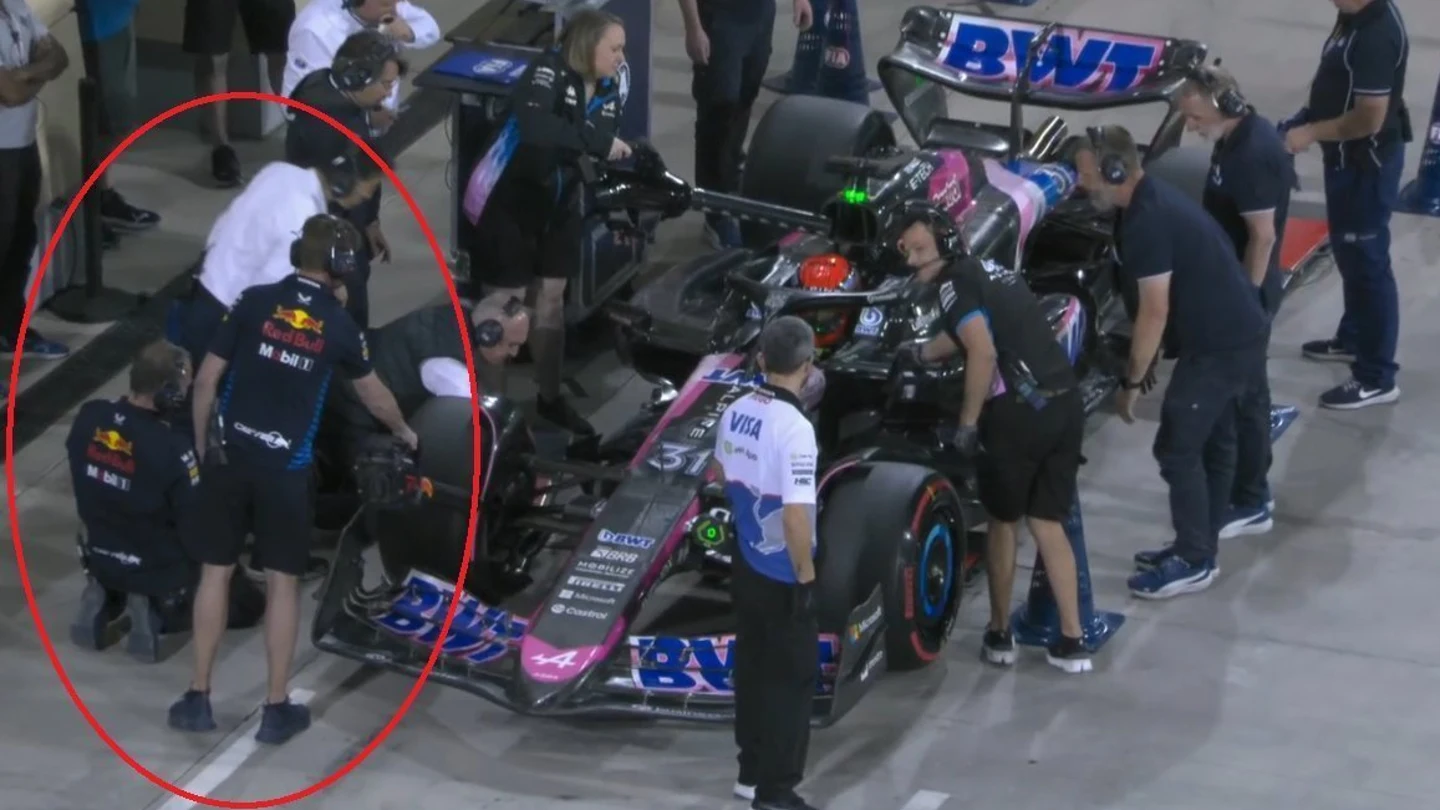 Un mecánico de Red Bull ayuda a refrigerar el Alpine de Esteban Ocon Un mecánico de Red Bull ayuda a refrigerar el Alpine de Esteban Ocon