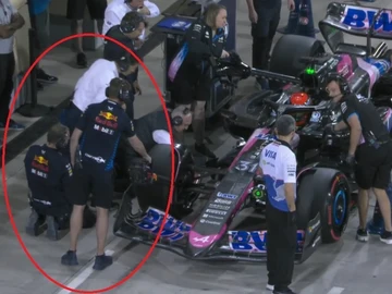 Un mecánico de Red Bull ayuda a refrigerar el Alpine de Esteban Ocon Un mecánico de Red Bull ayuda a refrigerar el Alpine de Esteban Ocon