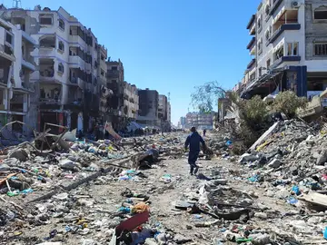  Personas inspeccionan los daños y recuperan artículos de sus hogares tras los ataques aéreos israelíes en el barrio de Al-Zaytoun en la ciudad de Gaza