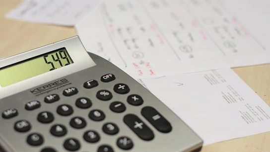 Imagen de archivo de una calculadora y facturas Imagen de archivo de una calculadora y facturas
