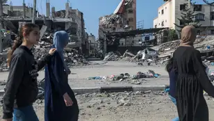 Mujeres paseando por zonas destruidas de Gazas tras ataques israelíes